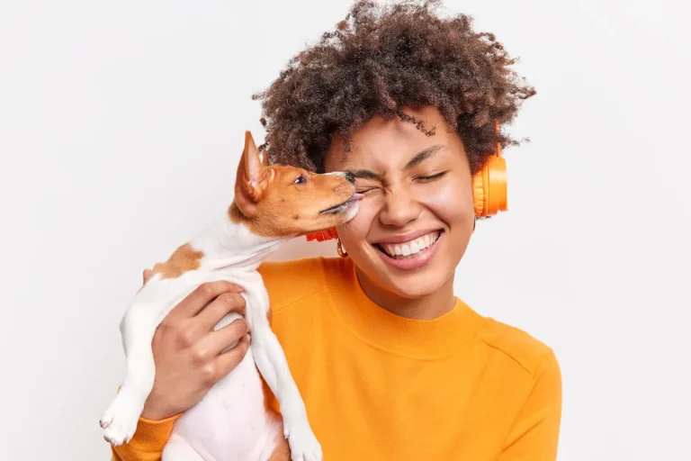 Un chien qui lèche les oreilles d'une femme